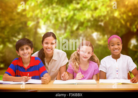 Immagine composita di pretty docente aiutare gli studenti nella libreria Foto Stock