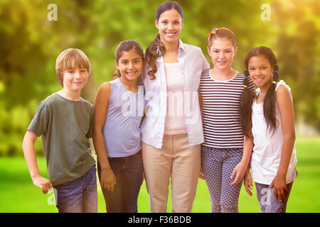 Immagine composita di graziosi gli alunni e gli insegnanti di sorridere alla telecamera in classe computer Foto Stock