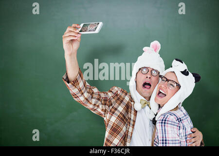 Immagine composita di geeky hipster giovane tenendo selfie con smart phone Foto Stock