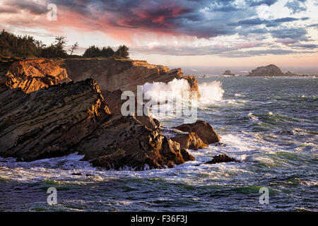 Ultima luce come le onde in arrivo crash contro le scogliere di arenaria di Oregon Riva dell acri del parco statale. Foto Stock