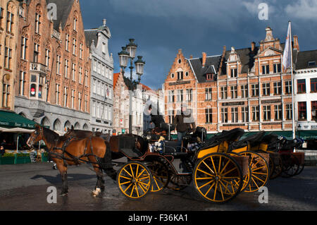 Bruges con carrozza a cavalli. La posizione centrale della piazza del mercato indica che questo è stato il cuore medievale della città Foto Stock