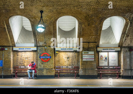 Uomo in attesa di un treno della metropolitana alla piattaforma della stazione metropolitana di Baker Street Londra Inghilterra UK GB Europe Foto Stock