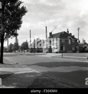 Vista storica del 1950 del negozio e dell'ufficio postale presso il villaggio modello di Stewartby, Bedford, Inghilterra, sede della London Brick Company, con i famosi camini in mattoni sullo sfondo. Foto Stock