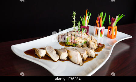 Saltata di lombo di coniglio e costolette con un medley di brani di fagioli e verdure Foto Stock