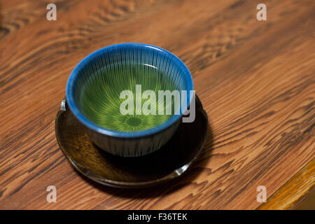 Verde in giapponese in Asia tazza da tè con montagne russe in legno e legno tabella di granella Foto Stock