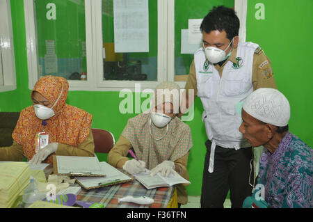 Makassar, Indonesia. 30 Settembre, 2015. Ufficiali medici esaminare un hajj indonesiano pellegrino (estrema destra) subito dopo il gruppo di hajj arriva a Sudiang Hajj Ostello a Makassar, Indonesia, il 30 settembre 2015.Indonesia defunti 168.800 hajj pellegrino in Arabia Saudita quest'anno, ma ci si aspetta hudred del pellegrino morti durante rencent hajj stagione. Indonesiano Afair religiosa non ha confermare il numero esatto di hajj morti dovuti alla raccolta di dati corretti a seguito della tragedia di Mina che ha ucciso circa 1000 pellegrino. Credito: Yermia Riezky Santiago/Alamy Live News Foto Stock