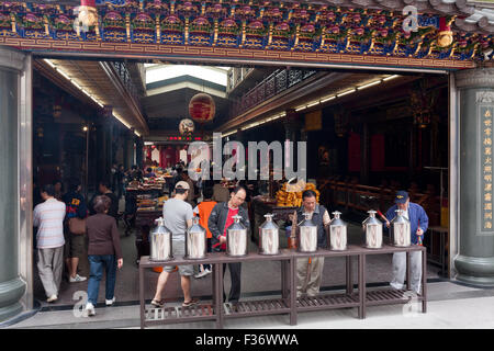 Persone che pregano e offrire incenso all'interno di Guandu tempio, Quartiere di Baeitou, Taipei City, Taiwan Foto Stock