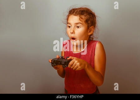 Ragazza aspetto europeo dieci anni tiene un joystick per giochi nel suo h Foto Stock