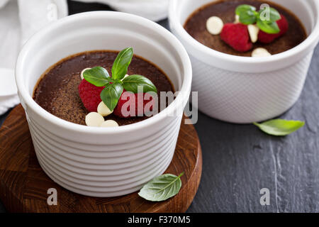 Pentole di cioccolato de creme dessert in ramekins con lamponi Foto Stock