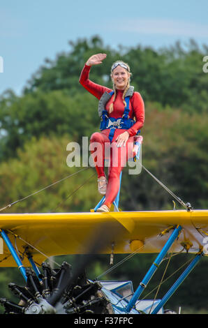 Emma Stewart Rigby ala a piedi in cima a un Boeing Stearman piano biplanare azionato da tattiche di Acrobazia Aerea a Damyns Hall, Essex Foto Stock