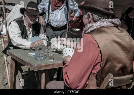 Ricreazione di un gioco di carte dell'epoca dei "cowboy" del selvaggio West USA. Desaturato. American West Enactment. Carte Foto Stock