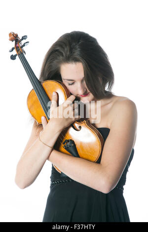 Bruna in nero si erge e detiene il violino in studio contro uno sfondo bianco Foto Stock