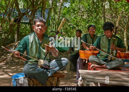 Gruppo di vittime di mine terrestri che suonano musica tradizionale Khmer vicino al tempio Ta Prohm. Parco Archeologico di Angkor, provincia di Siem Reap, Cambogia. Foto Stock