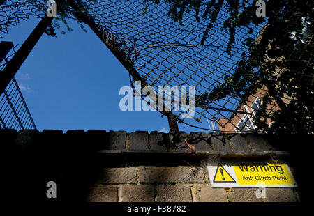 Avvertenza anti salita segno di vernice su un podere con il muro di recinzione rotto Foto Stock