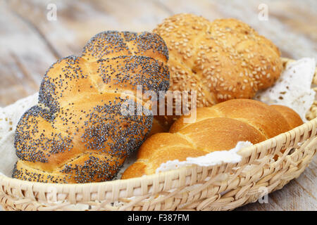 Challah pane con i semi di papavero Semi di sesamo e semplice nel cestino del pane Foto Stock