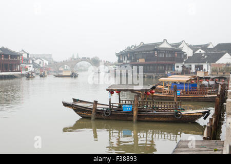 Barche in antichi canali di Zhūjiājiǎo a Shanghai in Cina, con il famoso Ponte Fangsheng in background. Foto Stock