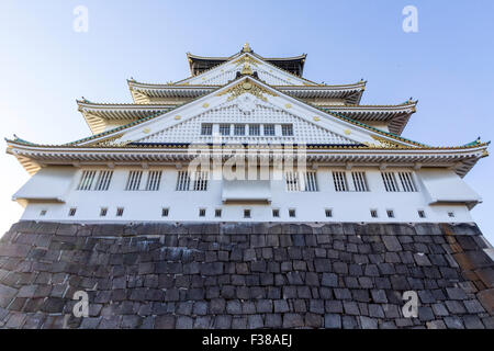 Il Castello di Osaka. Vista dal basamento in pietra del castello di guardare direttamente fino a mantenere la svettante al di sopra del visualizzatore. Soft mattina presto luce. Foto Stock