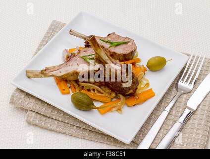 Grigliata di carré di agnello con olive, capperi e carote, vista dall'alto Foto Stock