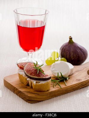 Formaggio di capra con fichi maturi e vino rosso, verticale Foto Stock