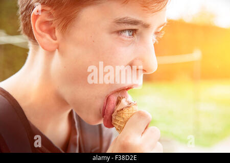 Ragazzo adolescente di mangiare un gelato Foto Stock