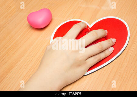 Mano femminile con il mouse del computer sul tavolo.Il giorno di san valentino Foto Stock