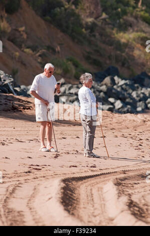 Coppia senior di camminare sulla spiaggia. Foto Stock