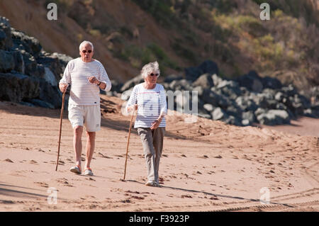 Coppia senior di camminare sulla spiaggia. Foto Stock