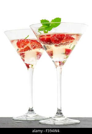 Cocktail alla fragola con frutti di bosco nella coppetta Martini isolati su sfondo bianco. Disposizione di festa con vino frizzante e fres Foto Stock