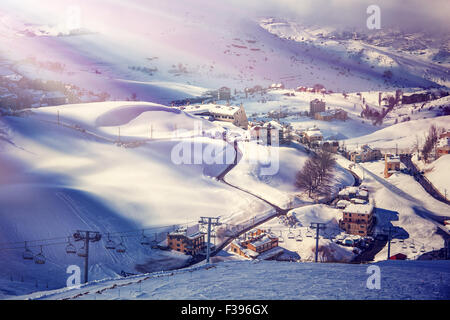 Vista aerea sulla bella stazione sciistica, montagna innevata, lusso piccoli cottage e chalet, trascorrendo le vacanze invernali Foto Stock