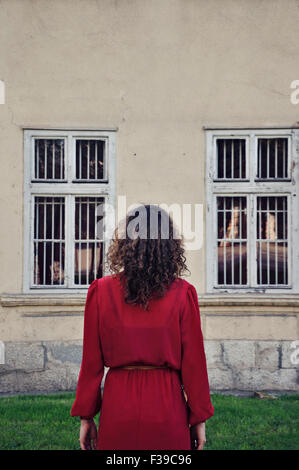 Donna in abito rosso in piedi all'aperto, vista posteriore Foto Stock