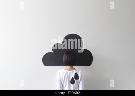 Vista posteriore di una donna camuffata da una nuvola concettuale Foto Stock