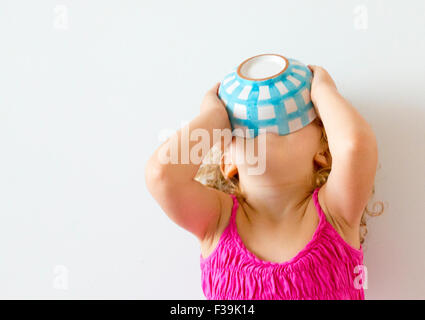 Ragazza con la testa indietro tenendo la ciotola di cereali alla sua bocca Foto Stock