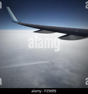 Aereo che vola nel cielo sopra un altro aereo commerciale Foto Stock