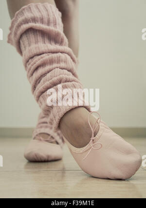 Close-up di una ragazza adolescente per le gambe, scarpe da ballo e gamba scaldabiberon Foto Stock