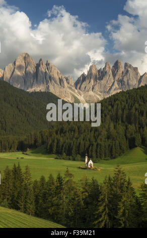 St Johann chiesa (San Giovanni) in una valle con le montagne sullo sfondo, Dolomiti, Alto Adige, Italia Foto Stock