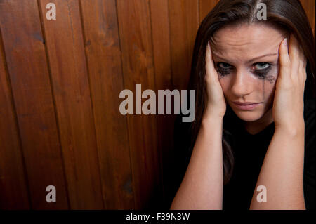 Lacrimoso giovane donna, con la testa con le mani. Foto Stock