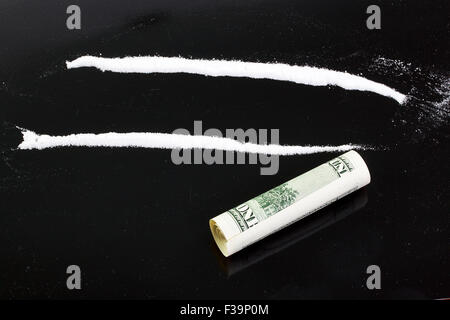 La cocaina in polvere in linee su uno sfondo nero Foto Stock
