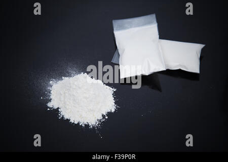 Trasparente sacchetti di plastica con polvere bianca isolata su sfondo nero Foto Stock