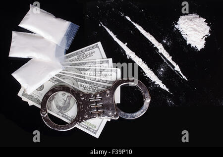 Cocaina e manette su sfondo nero Foto Stock