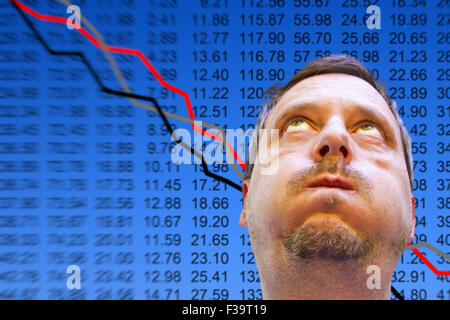 Preoccupato uomo di fronte a un grafico azionario Foto Stock