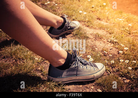 Una giovane donna di piedi e scarpe fuori in una giornata di sole Foto Stock