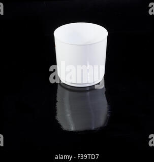 In plastica bianca tazza isolata su uno sfondo nero Foto Stock