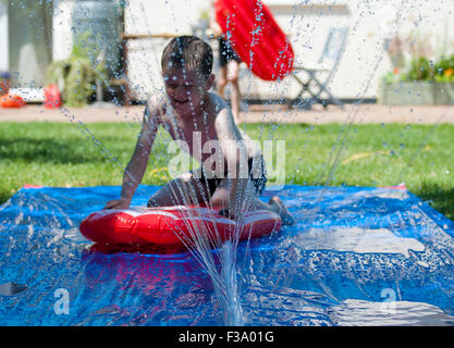 Ragazzo scivolare giù scorrere acqua Foto Stock