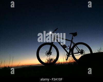 Laguna Beach, California, Stati Uniti d'America. Il 27 settembre, 2015. Un titanio singlespeed mountain bike con lezyne luce notturna al tramonto a 'Top del mondo' in Aliso Woods Canyon Park. Aliso Canyon di legno e Laguna Coast Wilderness Park si trovano in alcuni degli ultimi canyon costiera nel sud della California. Promontori rocciosi torre al di sopra del canyon trail. La costiera di macchia di salvia comunità copre colline e pendii, lungo con patch di Valle nativa savana e Maritime Chaparral. Laguna Coast Wilderness Park è parte della comunità naturale conservazione programma di pianificazione, che è progettato per proteggere rari Foto Stock