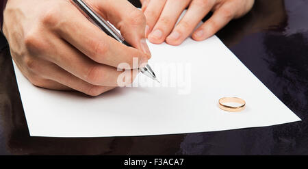 Primo piano della mano maschio firma carte di divorzio Foto Stock