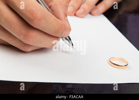 Primo piano della mano maschio firma carte di divorzio Foto Stock