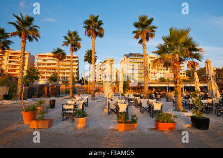 Ombrelloni e tavoli sulla spiaggia a Palaio Faliro in Atene, Grecia Foto Stock