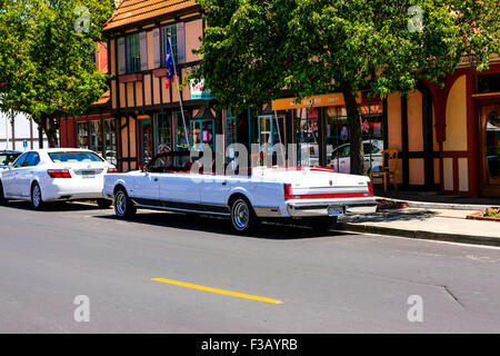 Un tratto convertible Cadillac limousine turistica in danese in stile villaggio da fiaba di Solvang in California Foto Stock