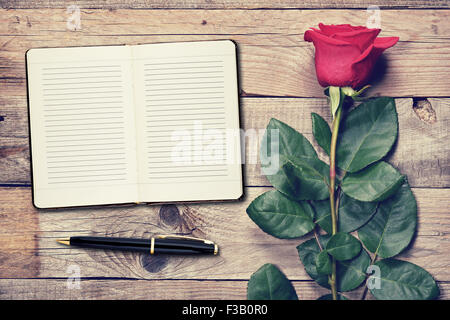 Vintage rose e Diario su sfondo di legno Foto Stock