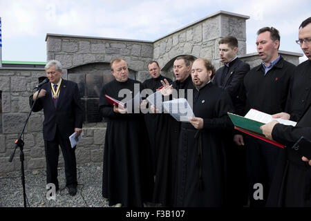 Lemnos Island, Grecia. 3 Ottobre, 2015. Russo coro ecclesiastico suonare dal vivo presso il memoriale di servizio detenuti per i caduti Russo-cosacchi e il Sig. Leonid Reshetnikov RISS (sinistra) pregare sul memoriale Russo-Kozak sito. Lemnos, Grecia. Credito: BasilT/Alamy Live News Foto Stock